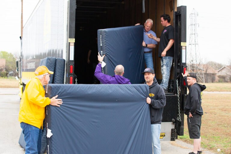 Men loading a trailer with mattress.