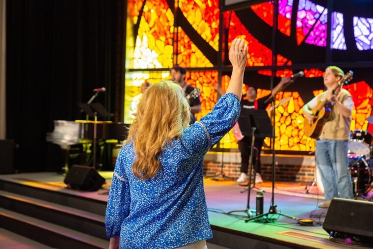 A women raises her hands in worship.