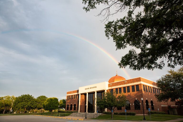 The Skiles building with a rainbow in the sky above it.