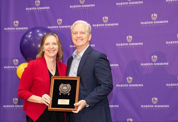 Dr. Jill Jumper accepting her award from President Bruntmyer on stage.