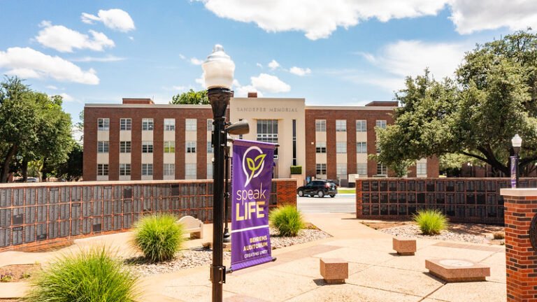 The Sandefer Building stands behind the Alumni Wall on campus at Hardin-Simmons University.
