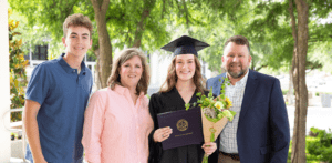 Girl student takes photo with family at graduation