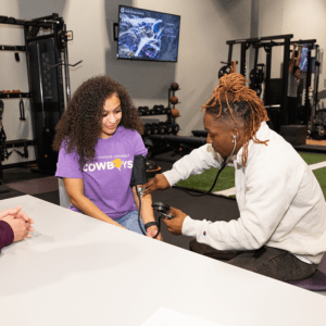 Two students practicing taking blood pressure