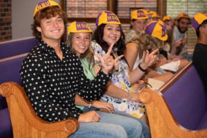 Students wear their beanies in Logsdon Chapel.