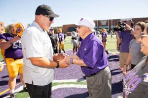 Coach Keeling handing Coach Burleson the game ball