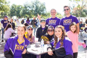 Family sitting at the Homecoming tailgate posed for a photo