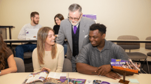 Dr. Doug McIntyre, Hardin-Simmons professor, discusses marketing collateral with students in the Kelley College of Business and Professional Studies undergraduate program.