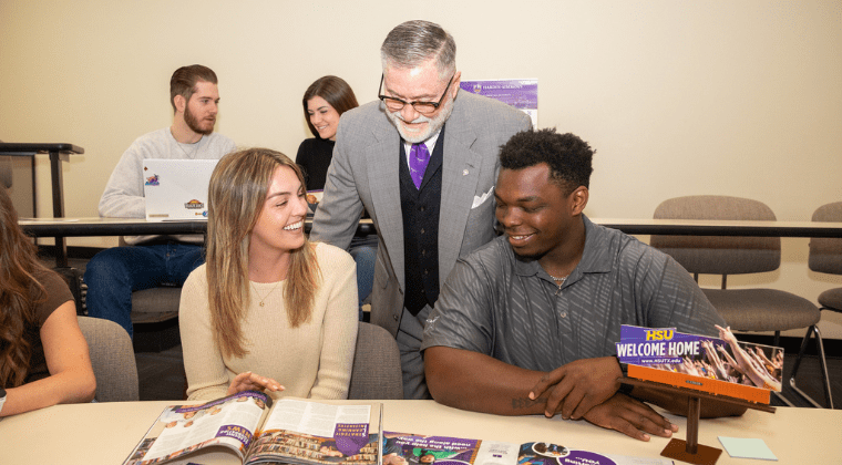 Dr. Doug McIntyre, Hardin-Simmons professor, discusses marketing collateral with students in the Kelley College of Business and Professional Studies undergraduate program.